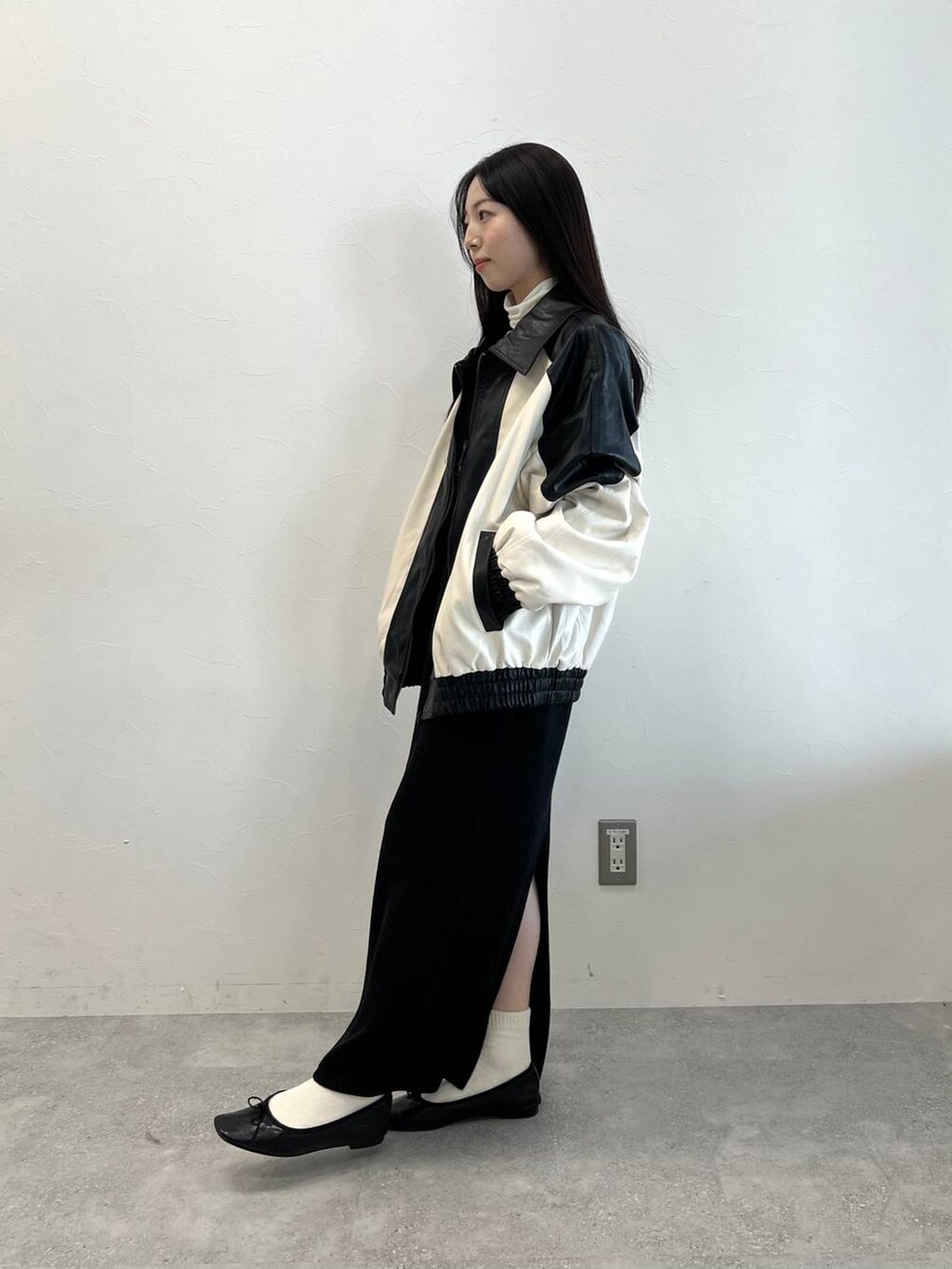 ブラック系のワンピース、ブラック系のバレエシューズ、ベージュ系のTシャツ/カットソーを着用したレディースの冬コーディネートの5枚目の写真