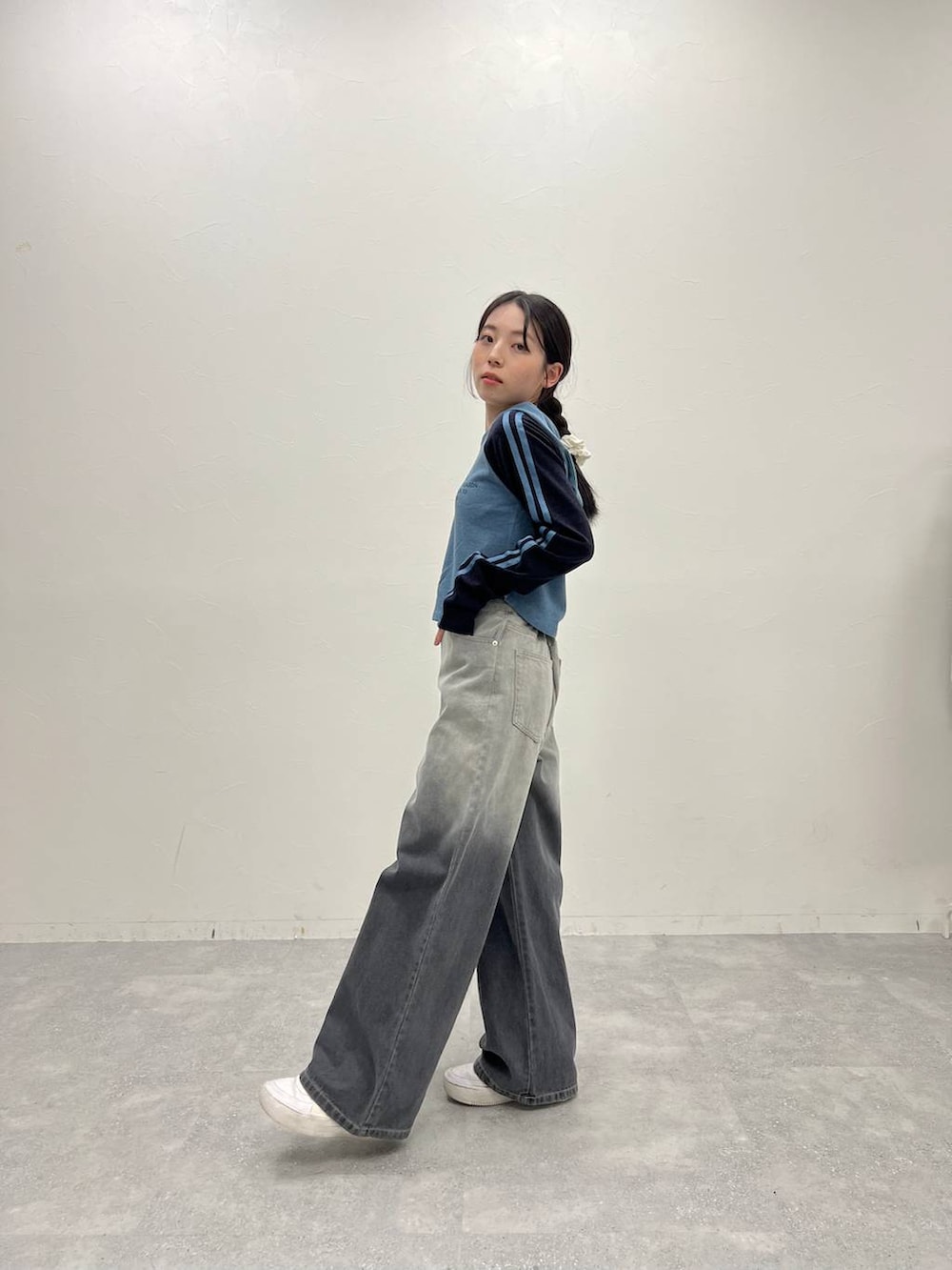 ブラック系のデニムパンツ、ホワイト系のスニーカー、ブルー系のTシャツ/カットソーを着用したレディースの冬コーディネートの2枚目の写真