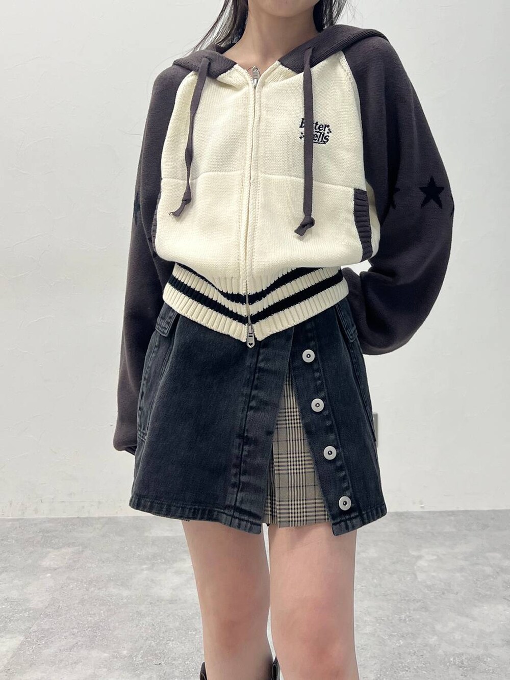 ブラウン系のスカート、ブラック系のデニムパンツを着用したレディースの春コーディネートの7枚目の写真