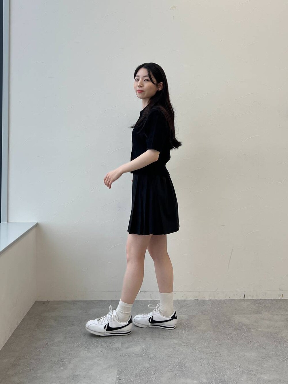 ブラック系のスカート、ブラック系のカーディガン/ボレロを着用したレディースの春コーディネートの2枚目の写真