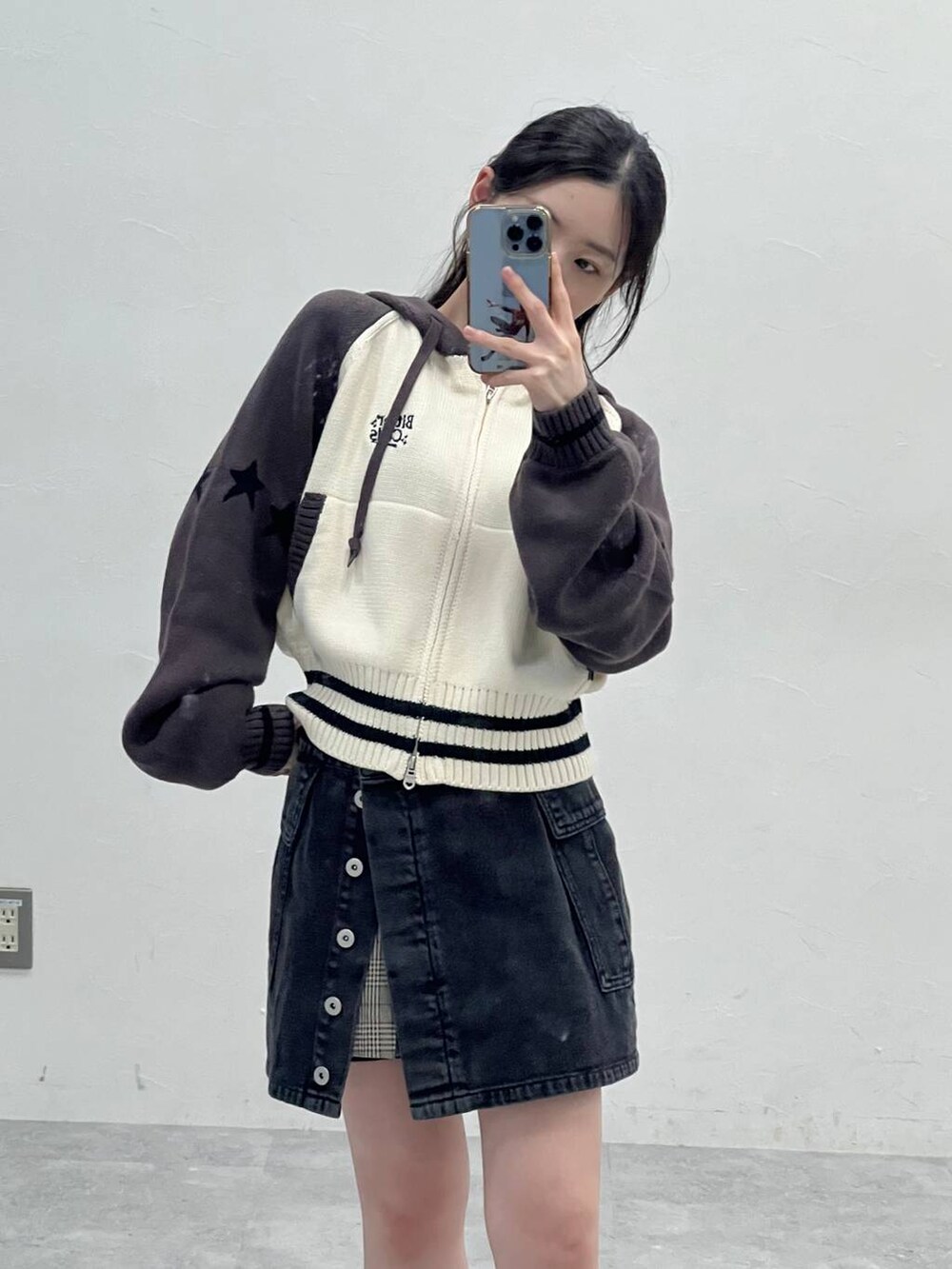 ブラウン系のスカート、ブラック系のデニムパンツを着用したレディースの春コーディネートの8枚目の写真