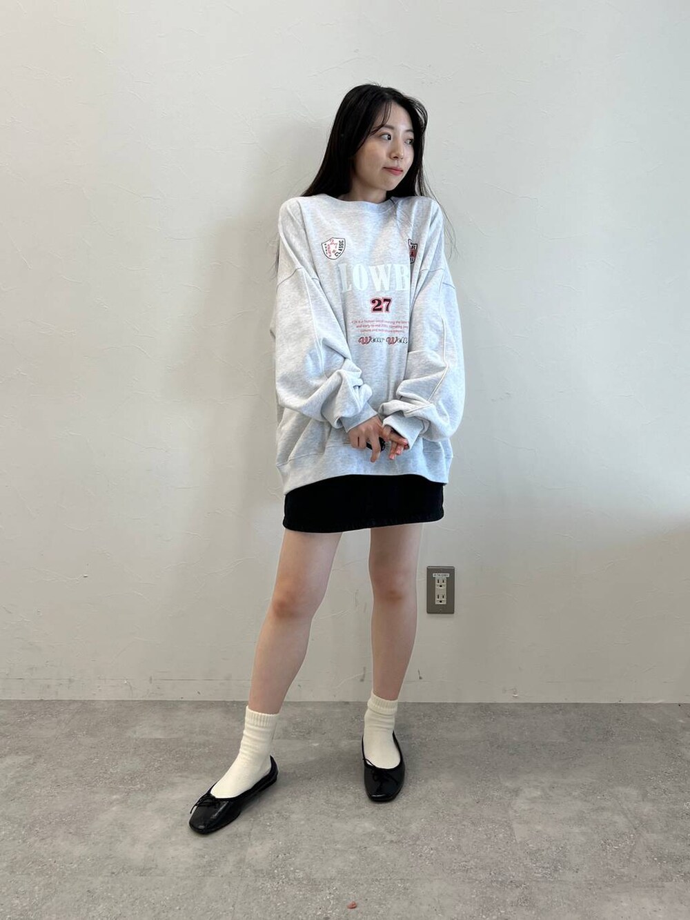 ブラック系のデニムスカート、ブラック系のバレエシューズ、グレー系のスウェットを着用したレディースの冬コーディネートの2枚目の写真