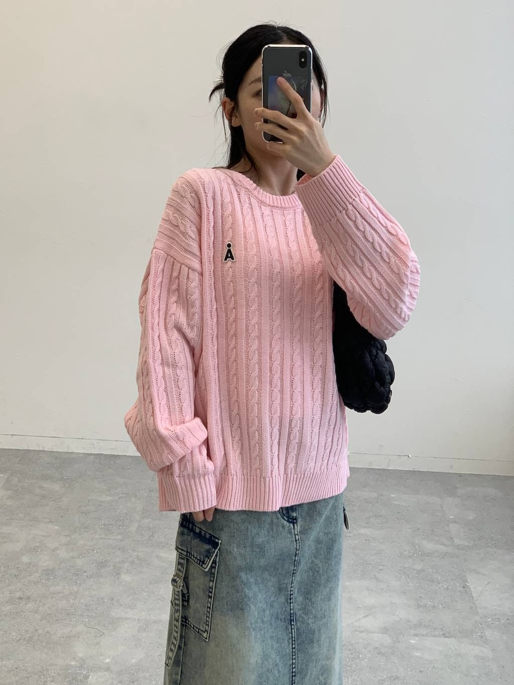 ブラック系のサンダル、ブラック系のショルダーバッグ、ブルー系のデニムスカートを着用したレディースの秋コーディネートの3枚目の写真