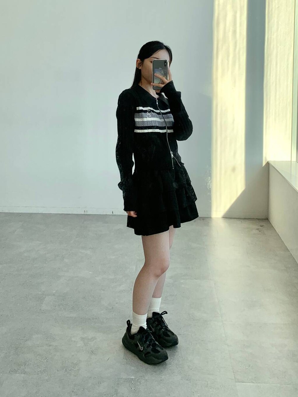 ブラック系のスカート、ブラック系のカーディガン/ボレロを着用したレディースの秋コーディネートの2枚目の写真