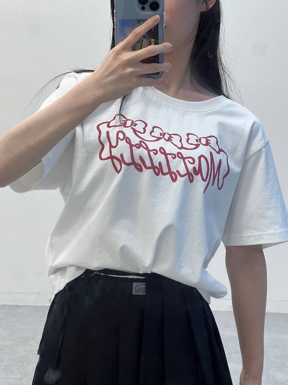 ブラック系のスカート、ホワイト系のTシャツ/カットソー、ブラック系のハンドバッグを着用したレディースの夏コーディネートの8枚目の写真