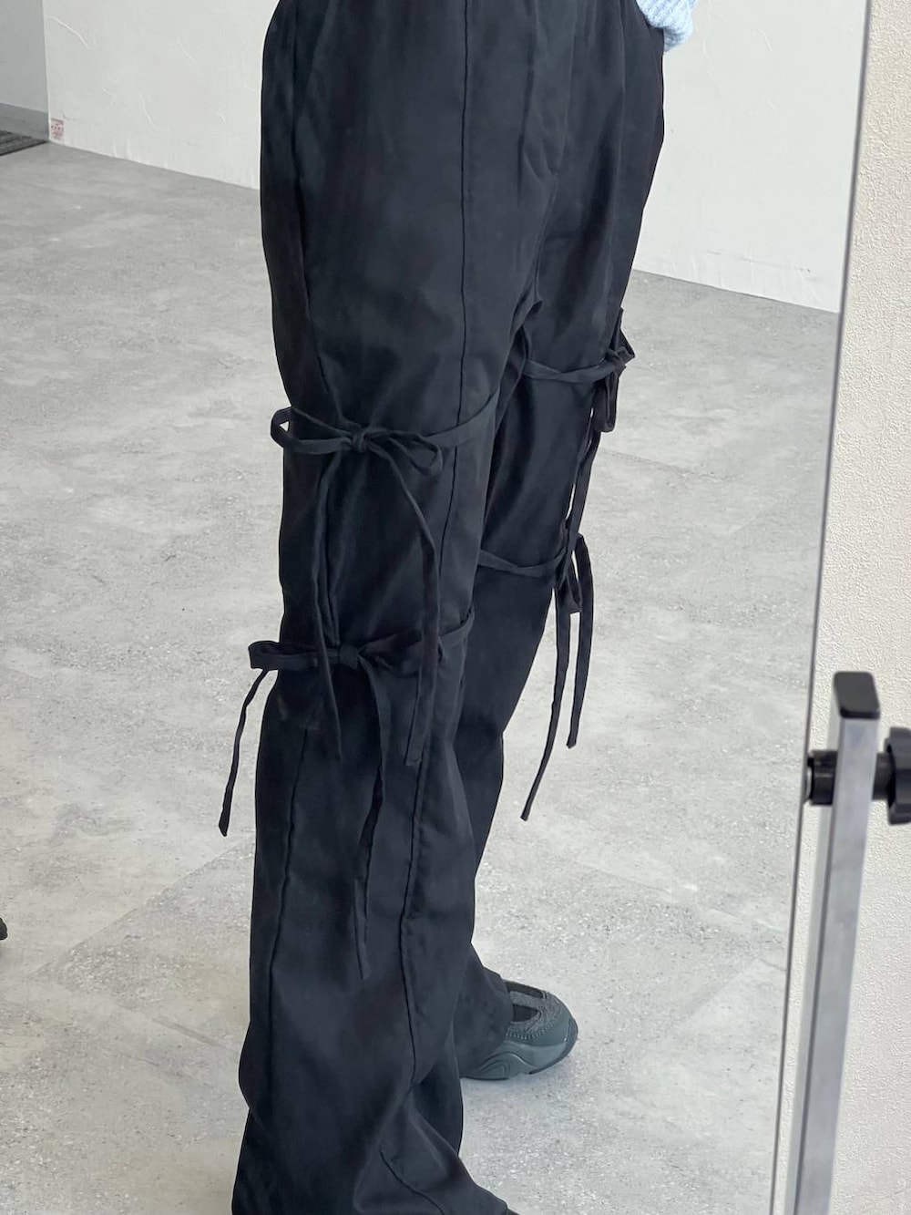 グレー系のショルダーバッグ、ベージュ系のTシャツ/カットソー、ブラック系のスラックスを着用したレディースの冬コーディネートの7枚目の写真