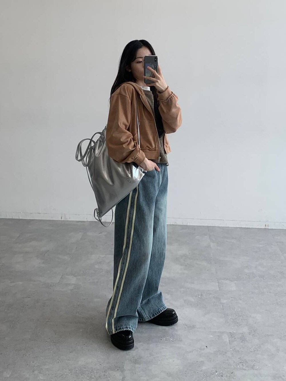 ブラウン系のパーカー、その他のデニムパンツ、グレー系のバックパック/リュックを着用したレディースの秋コーディネートの3枚目の写真