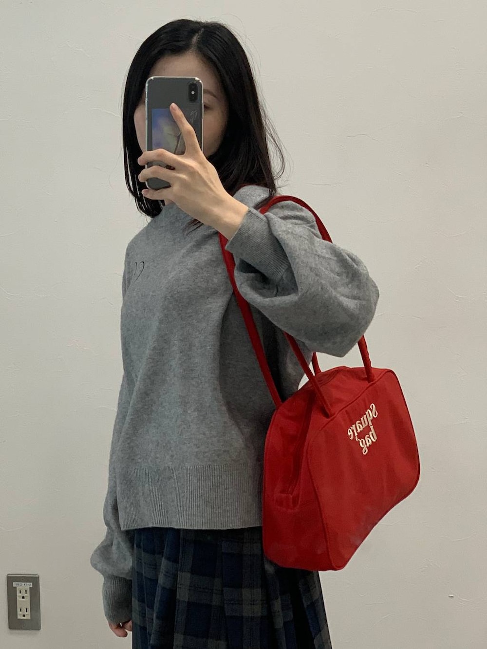 グレー系のニット/セーター、グレー系のスカートを着用したレディースの秋コーディネートの8枚目の写真