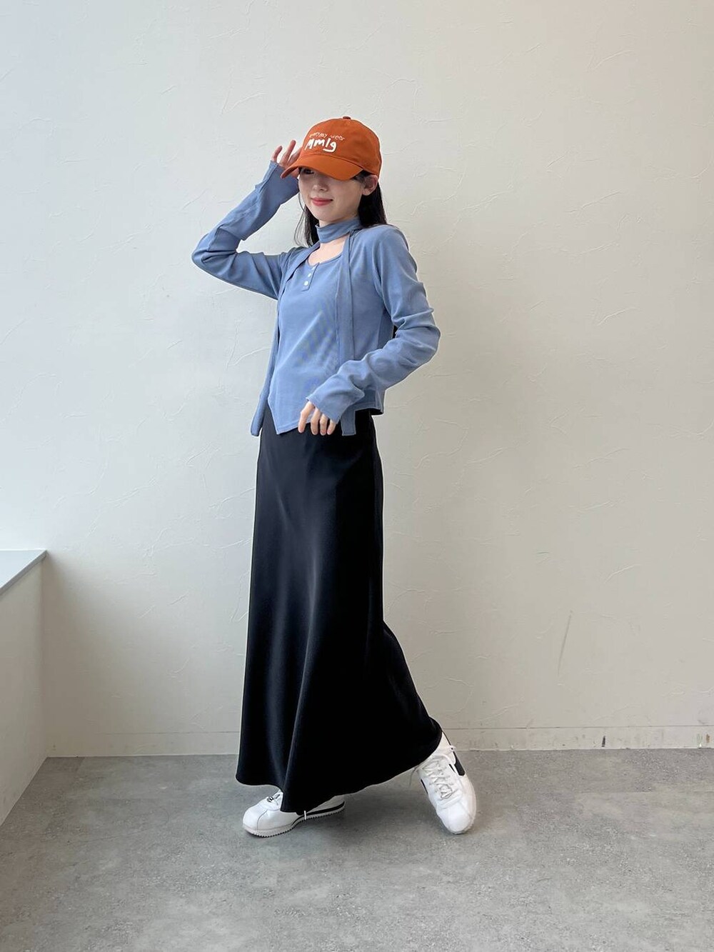 ブラック系のスカート、ブルー系のTシャツ/カットソー、ブラウン系のキャップを着用したレディースの春コーディネートの4枚目の写真