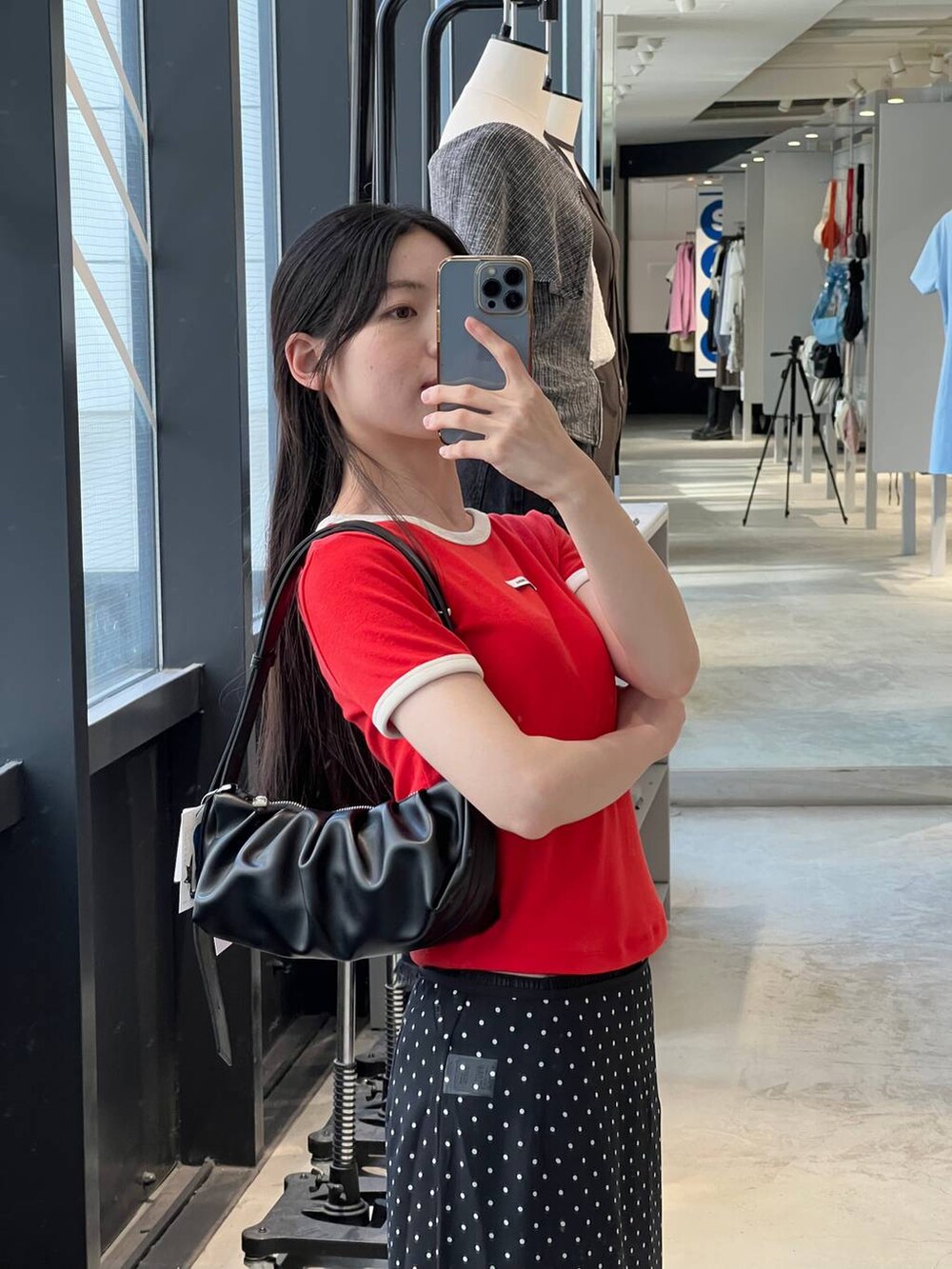 ブラック系のトートバッグ、ブラック系のスカート、レッド系のTシャツ/カットソーを着用したレディースの夏コーディネートの3枚目の写真