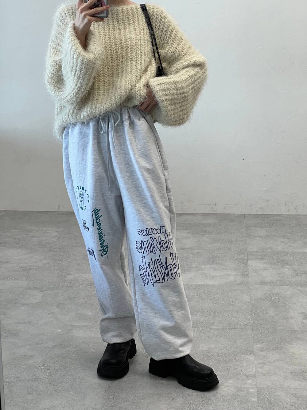 ブラック系のブーツ、ブラック系のショルダーバッグ、ベージュ系のニット/セーターを着用したレディースの冬コーディネートの8枚目の写真