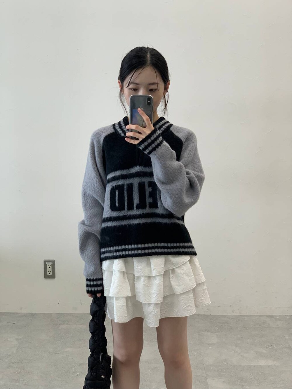 ブラック系のサンダル、ブラック系のショルダーバッグ、ホワイト系のスカートを着用したレディースの秋コーディネートの5枚目の写真