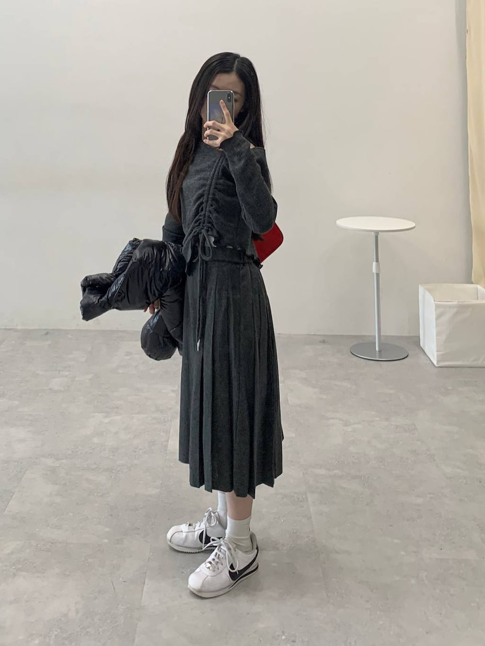 ブラック系のダウンジャケット/コート、グレー系のスカート、グレー系のTシャツ/カットソーを着用したレディースの冬コーディネートの2枚目の写真