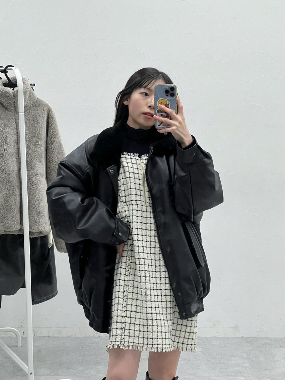 ブラック系のブーツ、ブラック系のブルゾン、ホワイト系のワンピースを着用したレディースの冬コーディネートの3枚目の写真