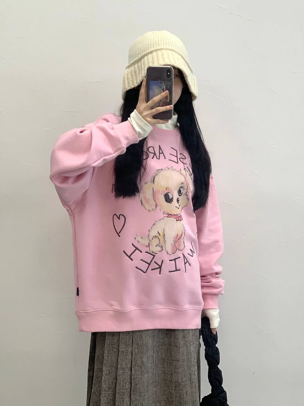 ブラック系のショルダーバッグ、ブラウン系のスカート、ピンク系のスウェットを着用したレディースの冬コーディネートの5枚目の写真