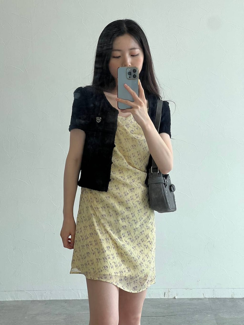 イエロー系のワンピース、ブラック系のトートバッグ、ブラック系のカーディガン/ボレロを着用したレディースの夏コーディネートの4枚目の写真