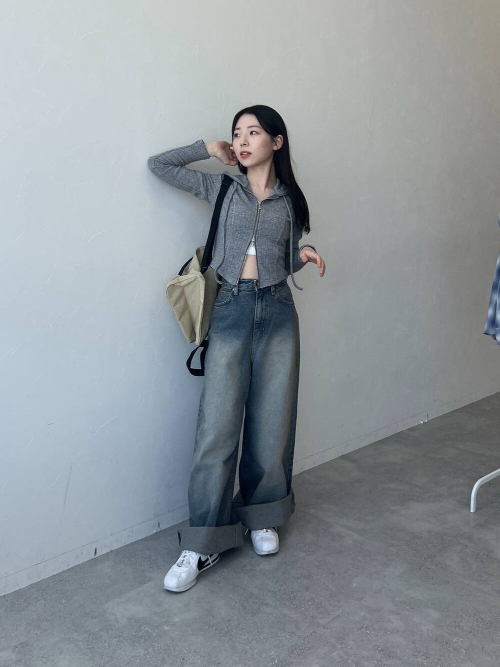 ブルー系のデニムパンツ、グレー系のTシャツ/カットソー、ベージュ系のバックパック/リュックを着用したレディースの春コーディネートの2枚目の写真