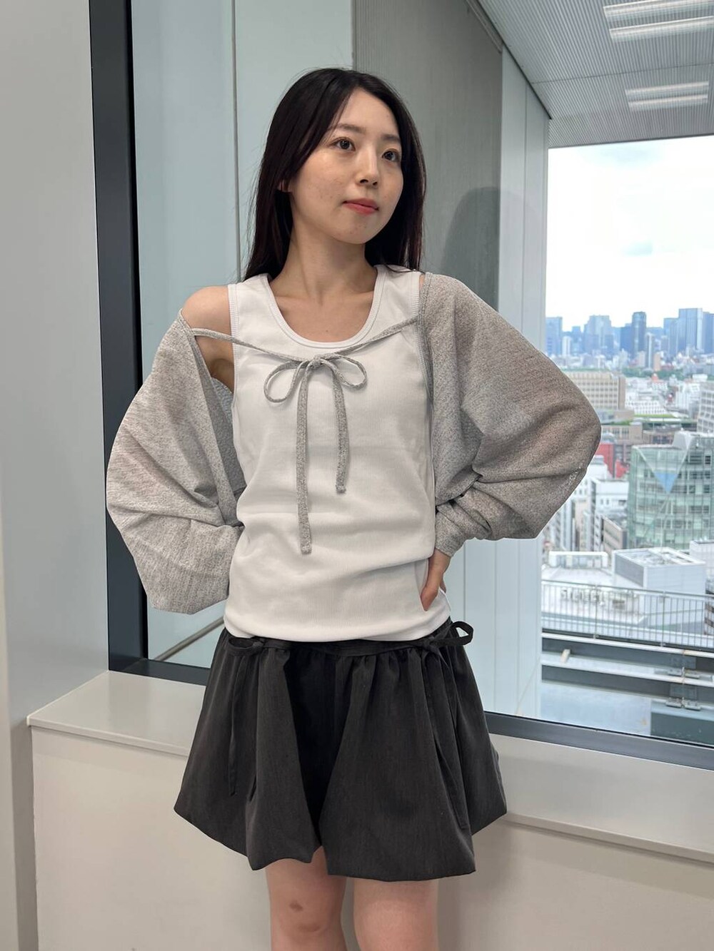 グレー系のスカート、ホワイト系のタンクトップ、グレー系のカーディガン/ボレロを着用したレディースの夏コーディネートの3枚目の写真