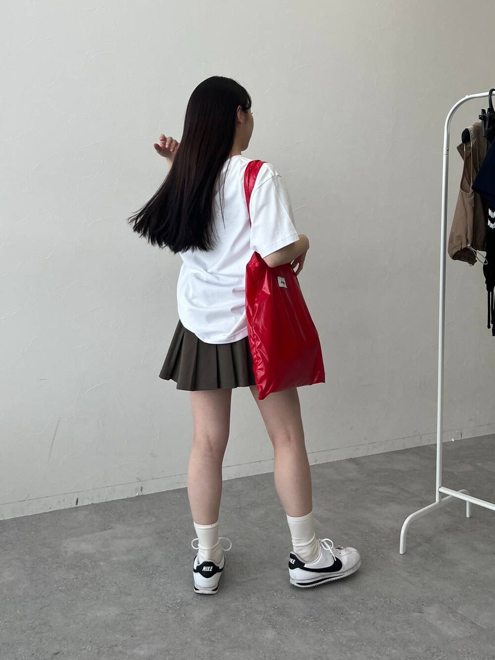 レッド系のトートバッグ、ホワイト系のTシャツ/カットソーを着用したレディースの春コーディネートの4枚目の写真