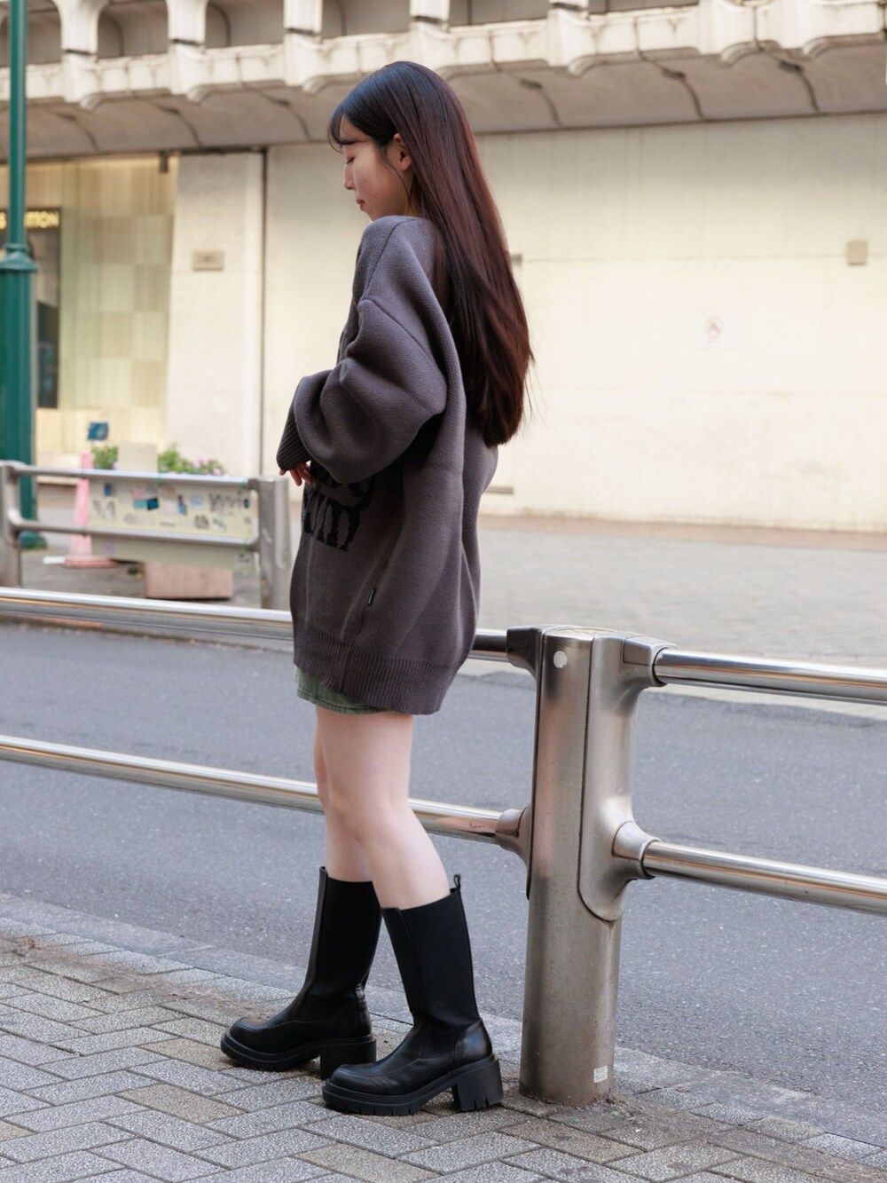 ブラック系のブーツ、グリーン系のスカート、グレー系のニット/セーターを着用したレディースの冬コーディネートの4枚目の写真