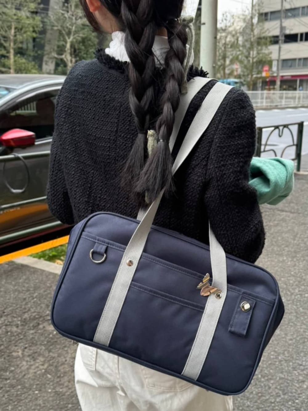 ブルー系のトートバッグ、ブラック系のジャケット/アウター、ホワイト系のTシャツ/カットソーを着用したレディースの冬コーディネートの5枚目の写真