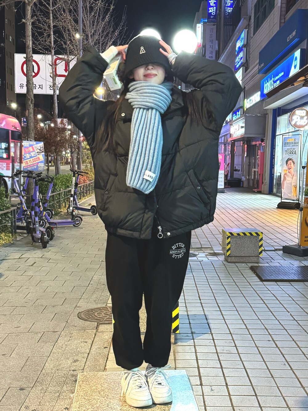 ブラック系のスウェットパンツ、ホワイト系のスニーカー、ブラック系のダウンジャケット/コートを着用したレディースの冬コーディネートの2枚目の写真