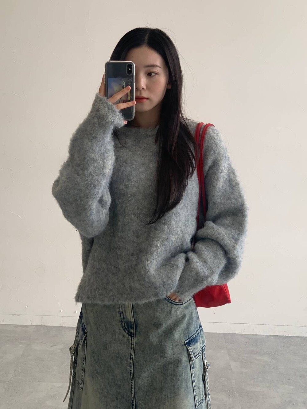 ブルー系のデニムスカート、グレー系のニット/セーターを着用したレディースの秋コーディネートの8枚目の写真