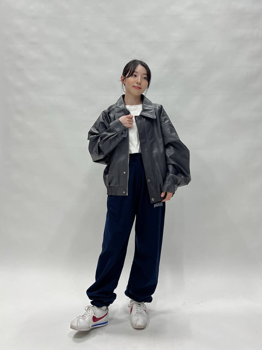 グレー系のブルゾン、ホワイト系のスニーカー、ブルー系のスウェットパンツを着用したレディースの冬コーディネートの2枚目の写真