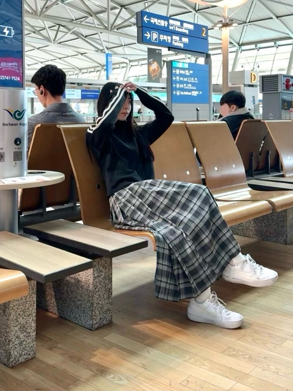 ホワイト系のスニーカー、グレー系のスカート、ブラック系のTシャツ/カットソーを着用したレディースの冬コーディネートの2枚目の写真