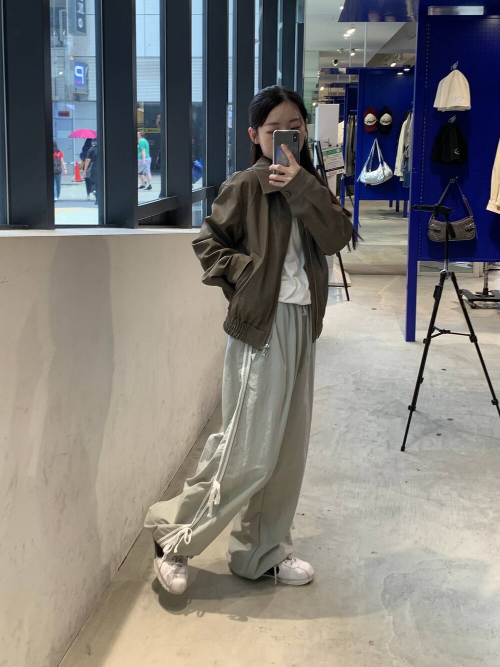 グレー系のその他パンツ、ホワイト系のTシャツ/カットソー、ブラウン系のライダースジャケットを着用したレディースの秋コーディネートの2枚目の写真