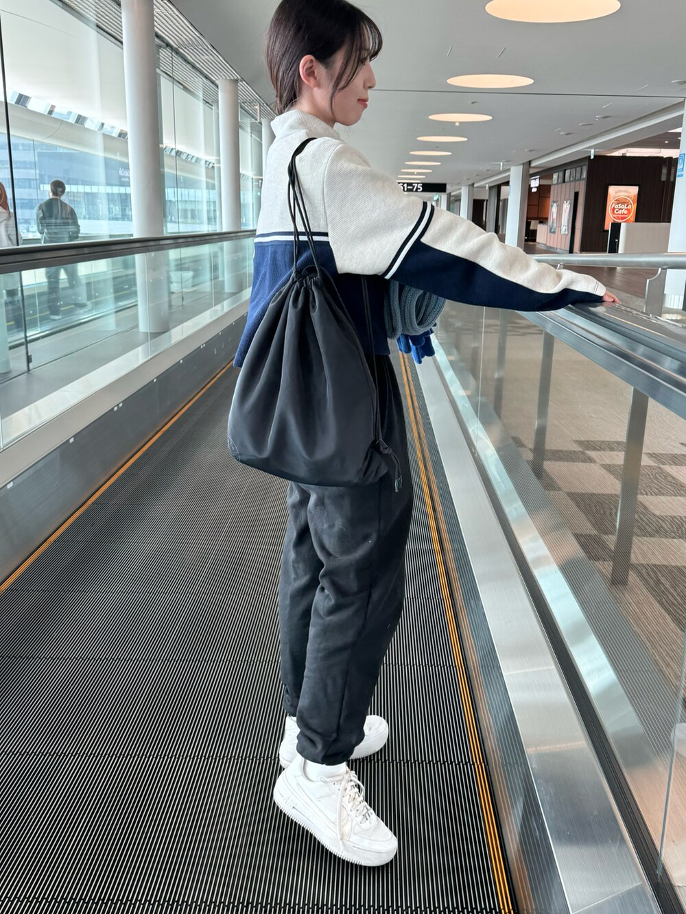 ホワイト系のスニーカー、ブラック系のスウェットパンツ、ブラック系のスウェットパンツを着用したレディースの秋コーディネートの3枚目の写真