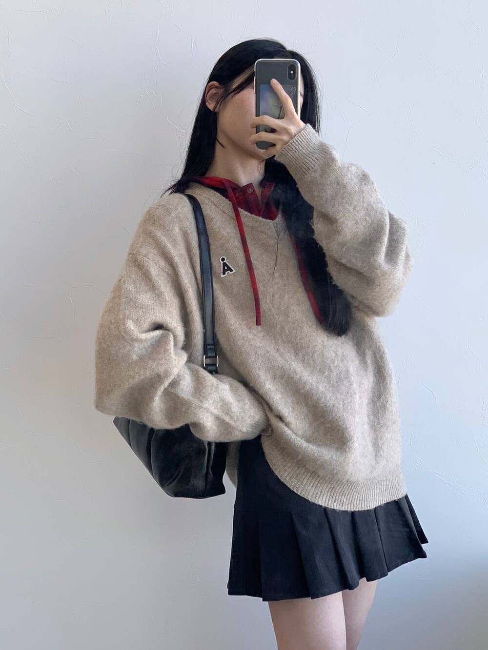 レッド系のシャツ/ブラウス、グレー系のスカート、ブラック系のハンドバッグを着用したレディースの冬コーディネートの6枚目の写真