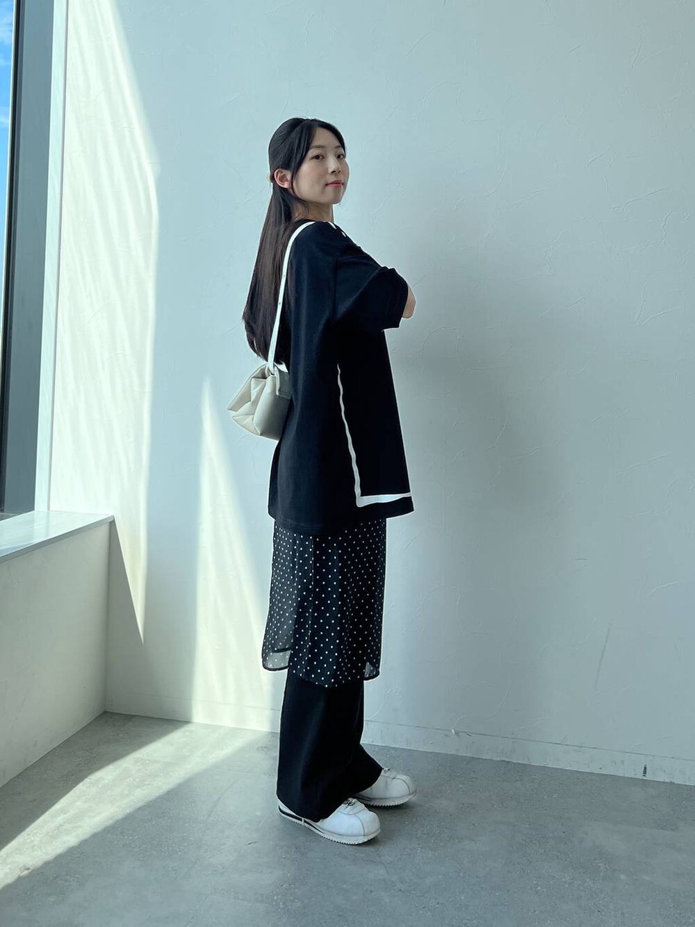 ホワイト系のハンドバッグ、ブラック系のスカートを着用したレディースの夏コーディネートの3枚目の写真