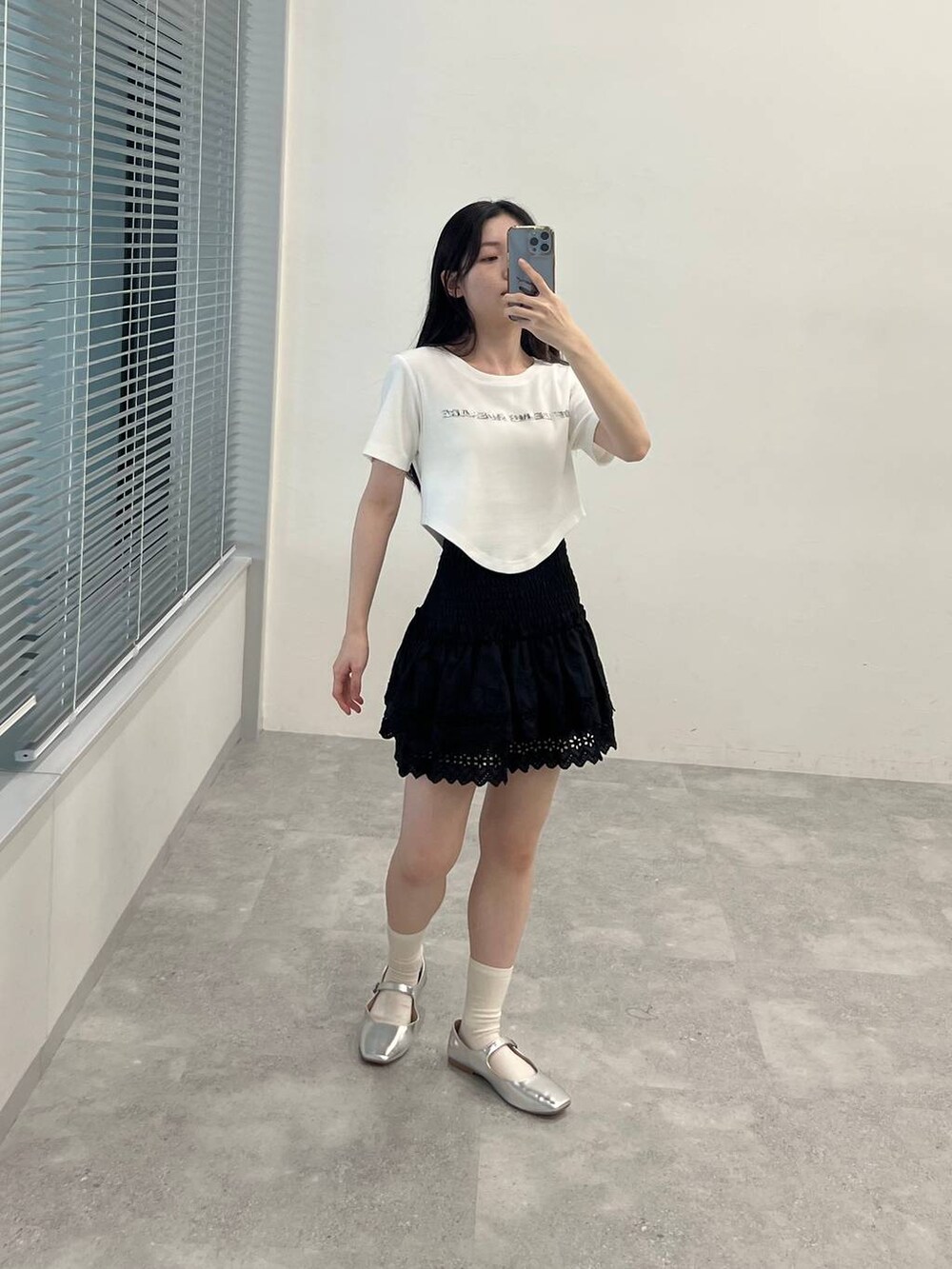 ブラック系のスカート、ホワイト系のTシャツ/カットソーを着用したレディースの春コーディネートの4枚目の写真