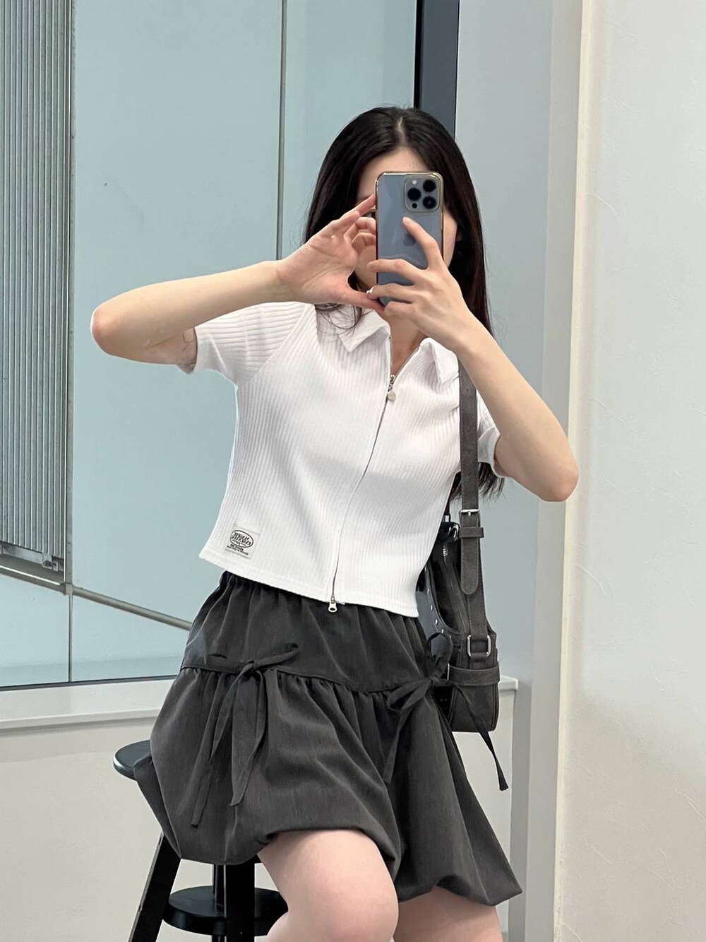 グレー系のスカート、ブラック系のトートバッグ、ホワイト系のカーディガン/ボレロを着用したレディースの夏コーディネートの7枚目の写真