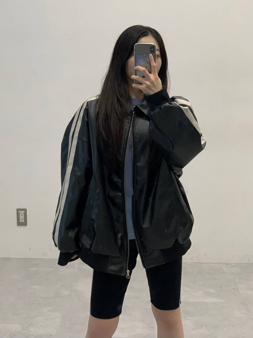 ブラック系のサンダル、ブラック系のブルゾン、ブルー系のTシャツ/カットソーを着用したレディースの秋コーディネートの4枚目の写真