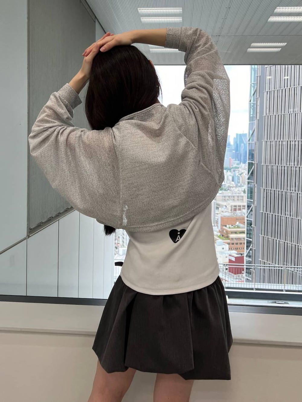 グレー系のスカート、ホワイト系のタンクトップ、グレー系のカーディガン/ボレロを着用したレディースの夏コーディネートの4枚目の写真