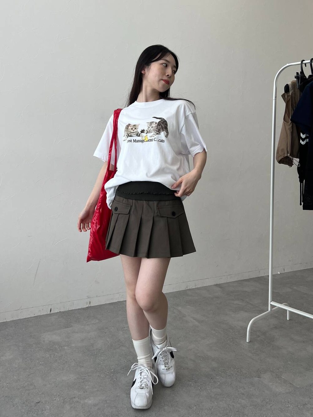 レッド系のトートバッグ、ホワイト系のTシャツ/カットソーを着用したレディースの春コーディネートの5枚目の写真