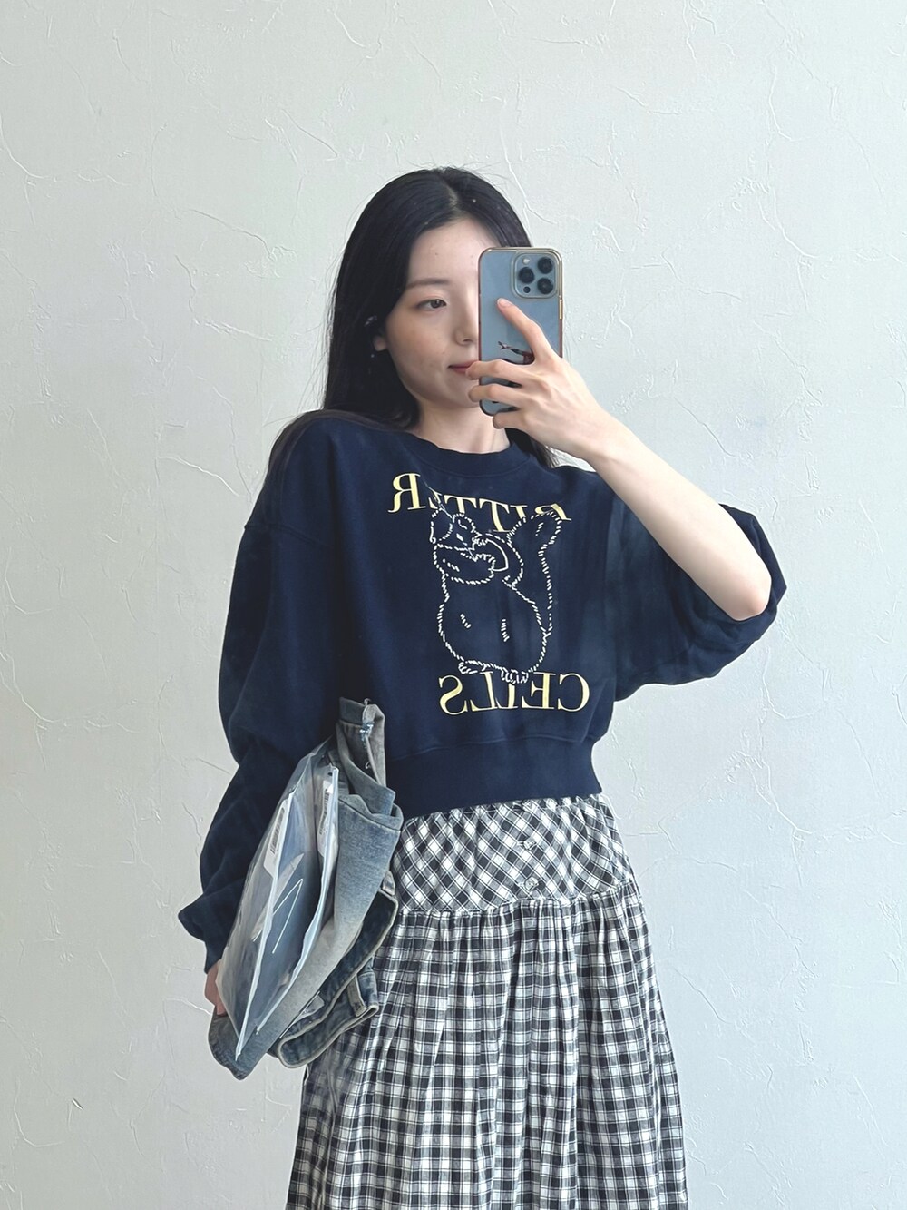 ブラック系のスカート、ブルー系のスウェットを着用したレディースの春コーディネートの2枚目の写真