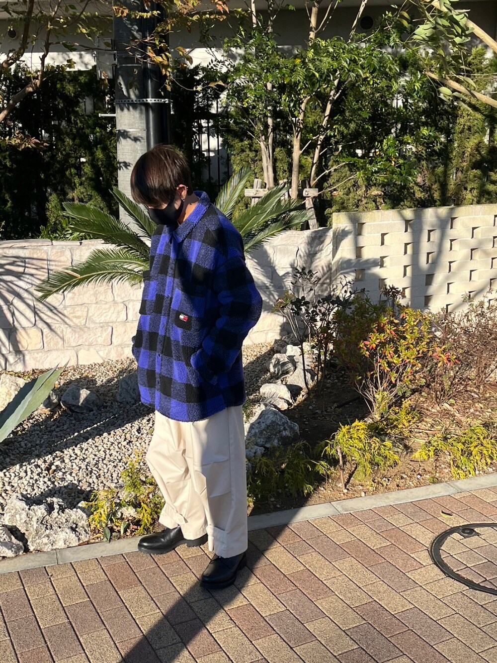 オレンジ系のニット/セーター、ホワイト系のその他パンツ、ホワイト系のシャツ/ブラウスを着用したメンズの冬コーディネートの2枚目の写真