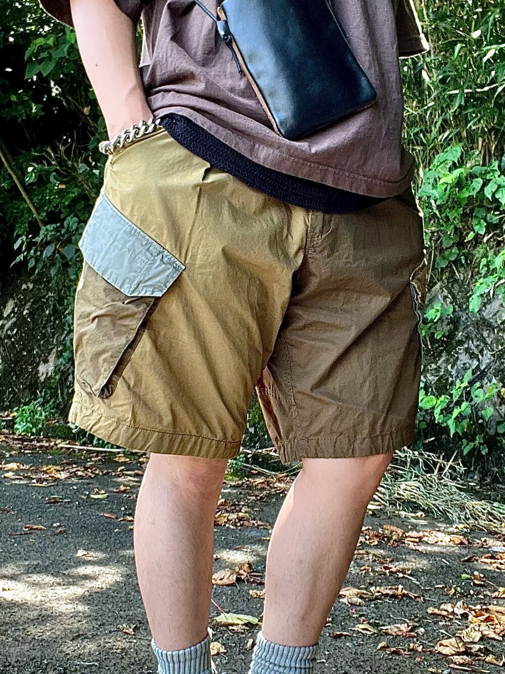 ベージュ系のサンダル、グリーン系のカーゴパンツ、ブラック系のタンクトップを着用したメンズの夏コーディネートの3枚目の写真