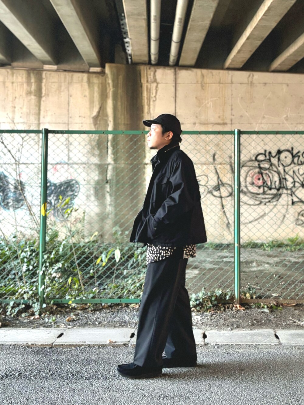 ブラック系のモカシン/デッキシューズ、ブラック系のスラックス、ブラック系のブルゾンを着用したメンズの冬コーディネートの2枚目の写真