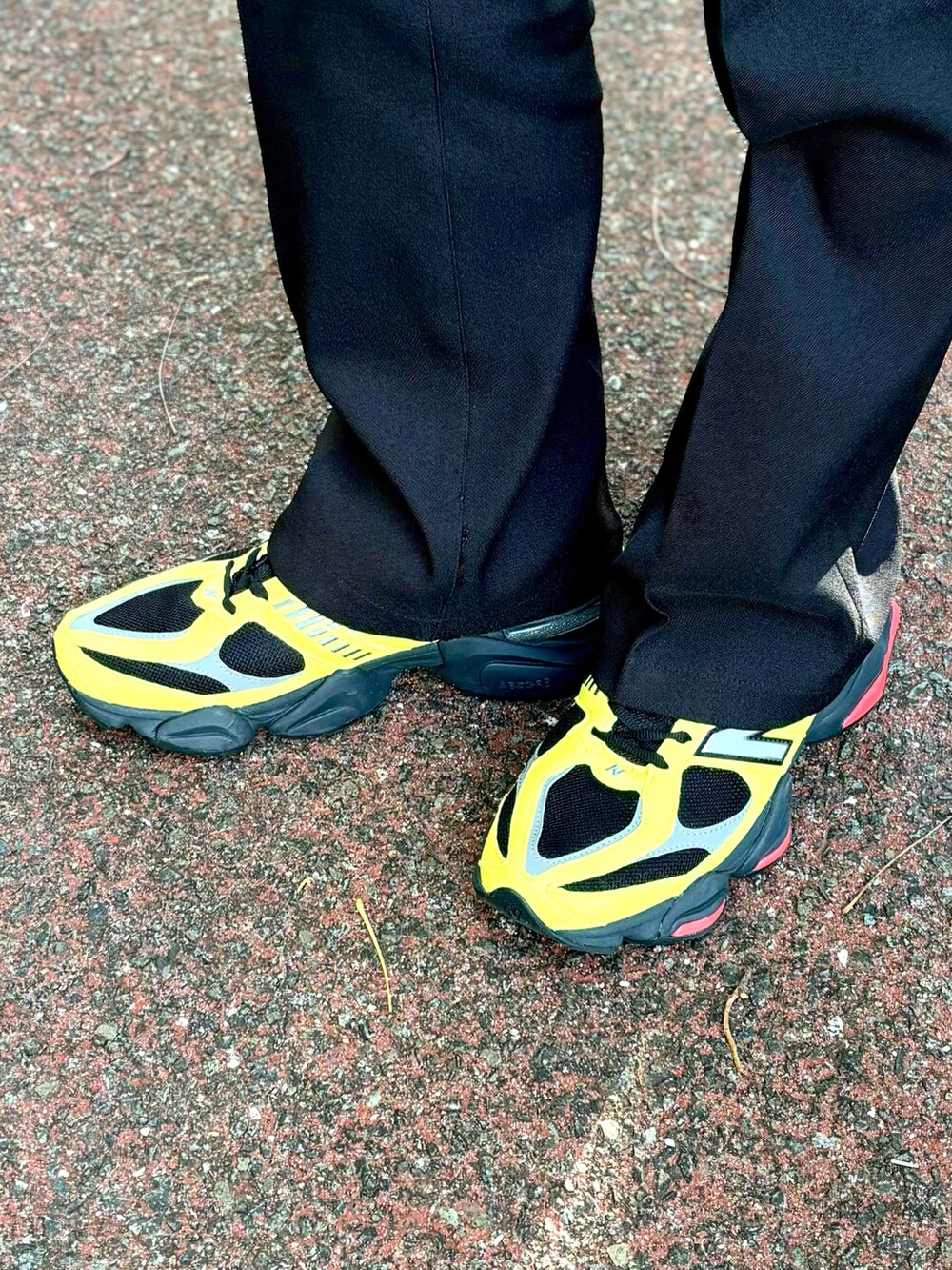 イエロー系のスニーカー、ブラック系のスラックス、グリーン系のMA-1を着用したメンズの冬コーディネートの4枚目の写真