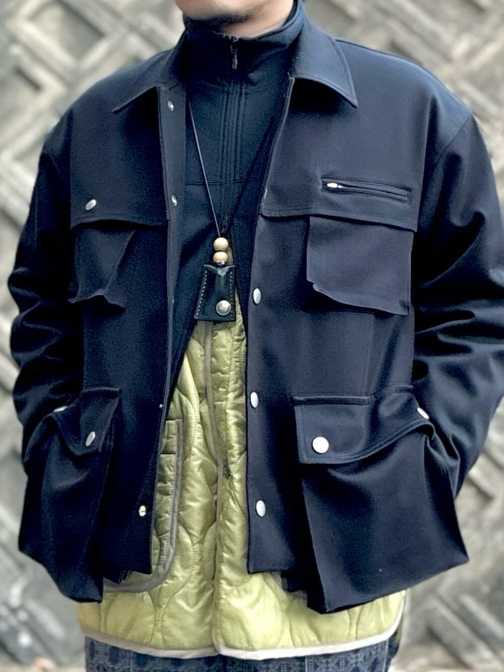 ブラック系のミリタリージャケット、ブラック系のブルゾン、ベージュ系のミリタリージャケットを着用したメンズの冬コーディネートの4枚目の写真