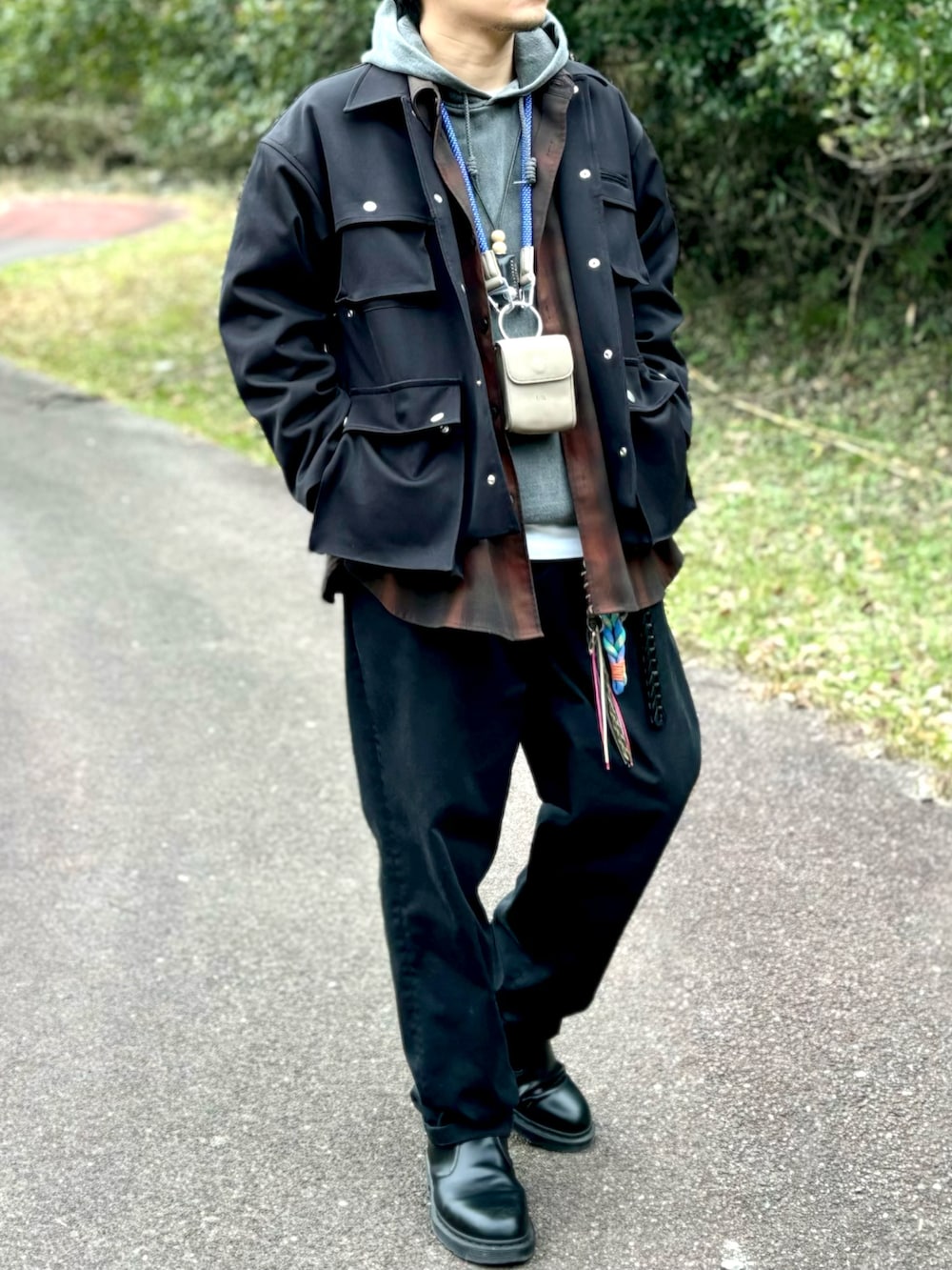 ブラック系のブーツ、ブラック系のチノパンツ、ブラック系のミリタリージャケットを着用したメンズの冬コーディネートの3枚目の写真