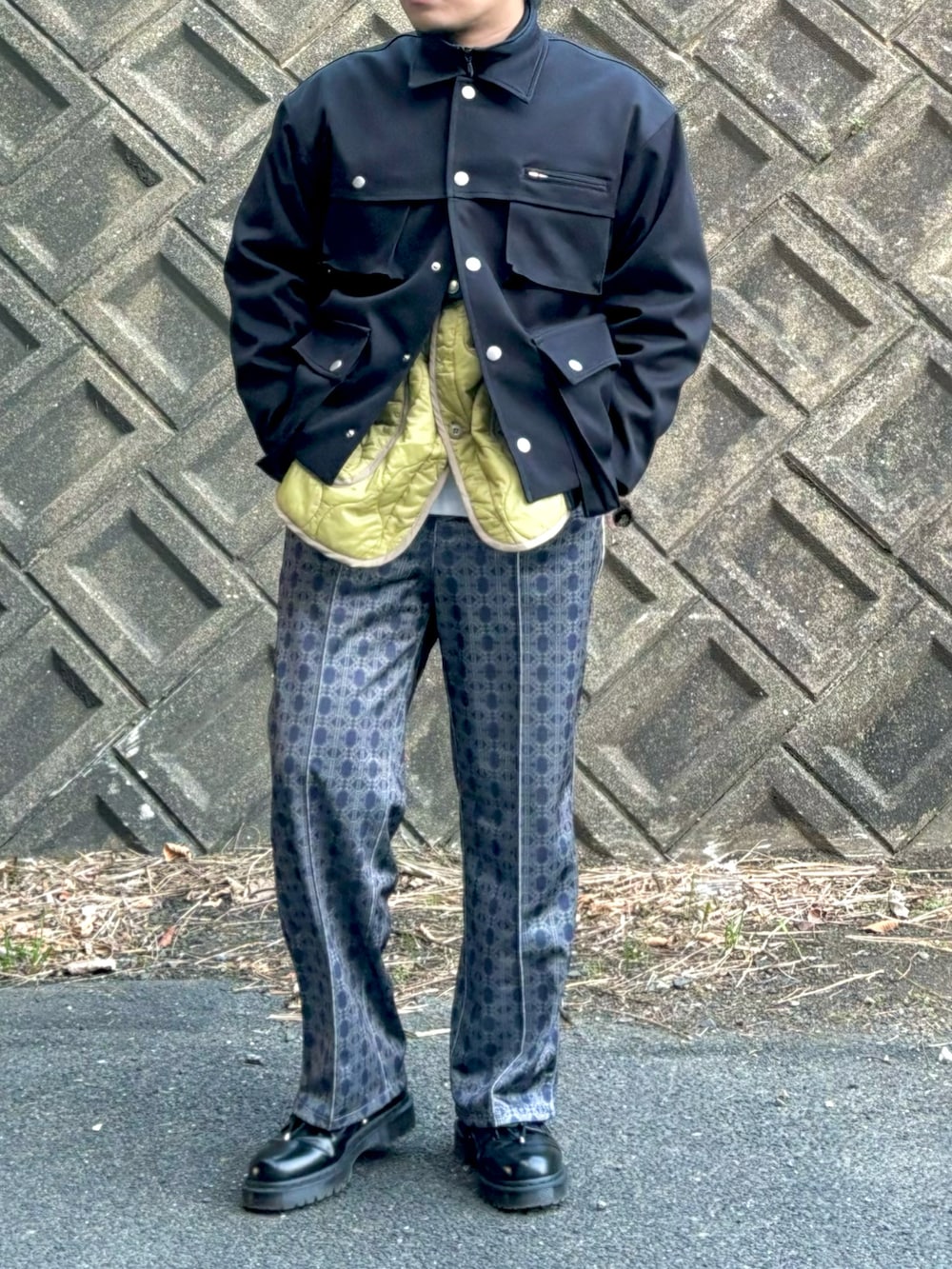 ブラック系のミリタリージャケット、ブラック系のブルゾン、ベージュ系のミリタリージャケットを着用したメンズの冬コーディネートの3枚目の写真