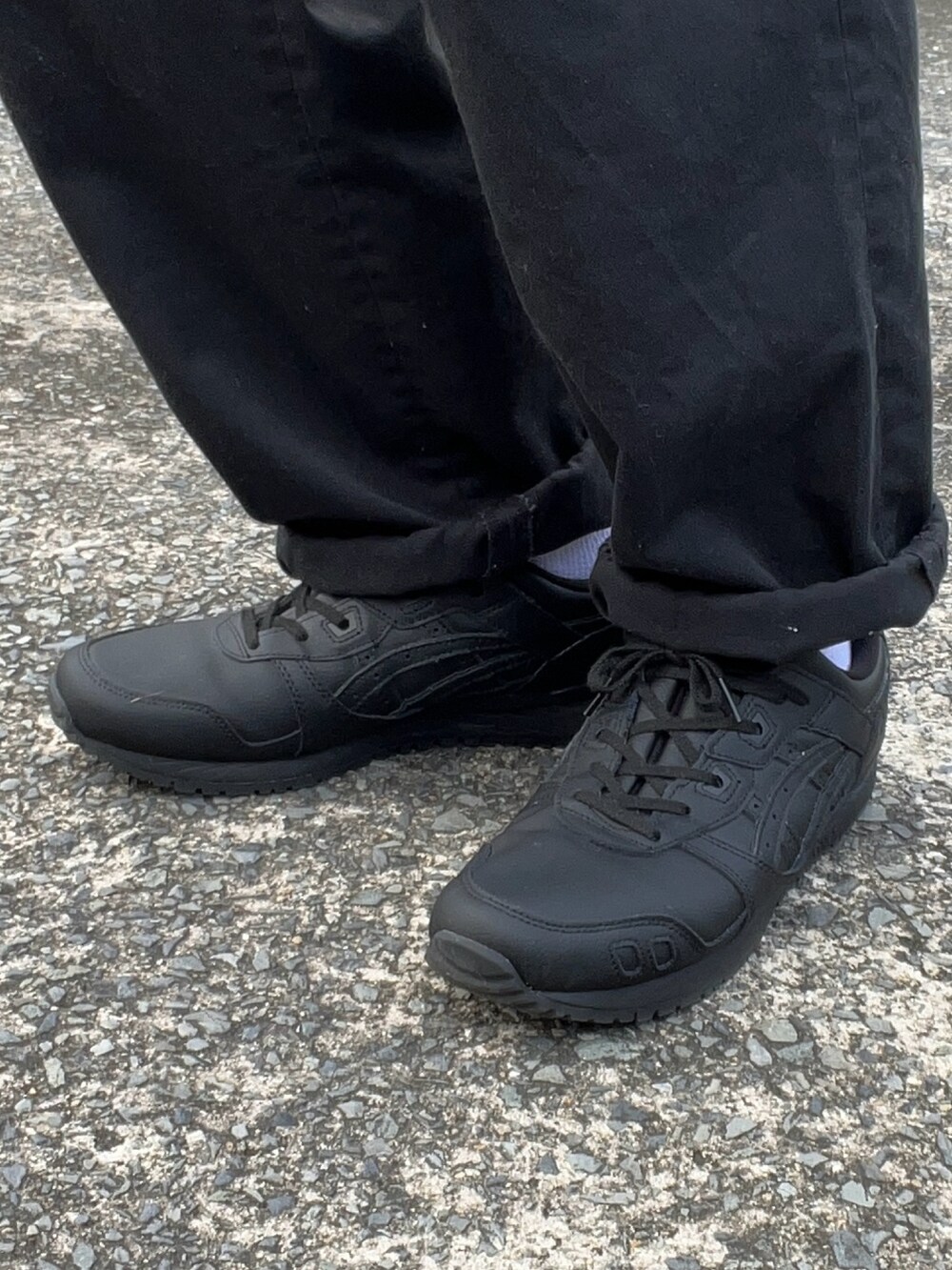 ブラック系のスニーカー、ブラック系のチノパンツ、ブラック系のベストを着用したメンズの夏コーディネートの5枚目の写真