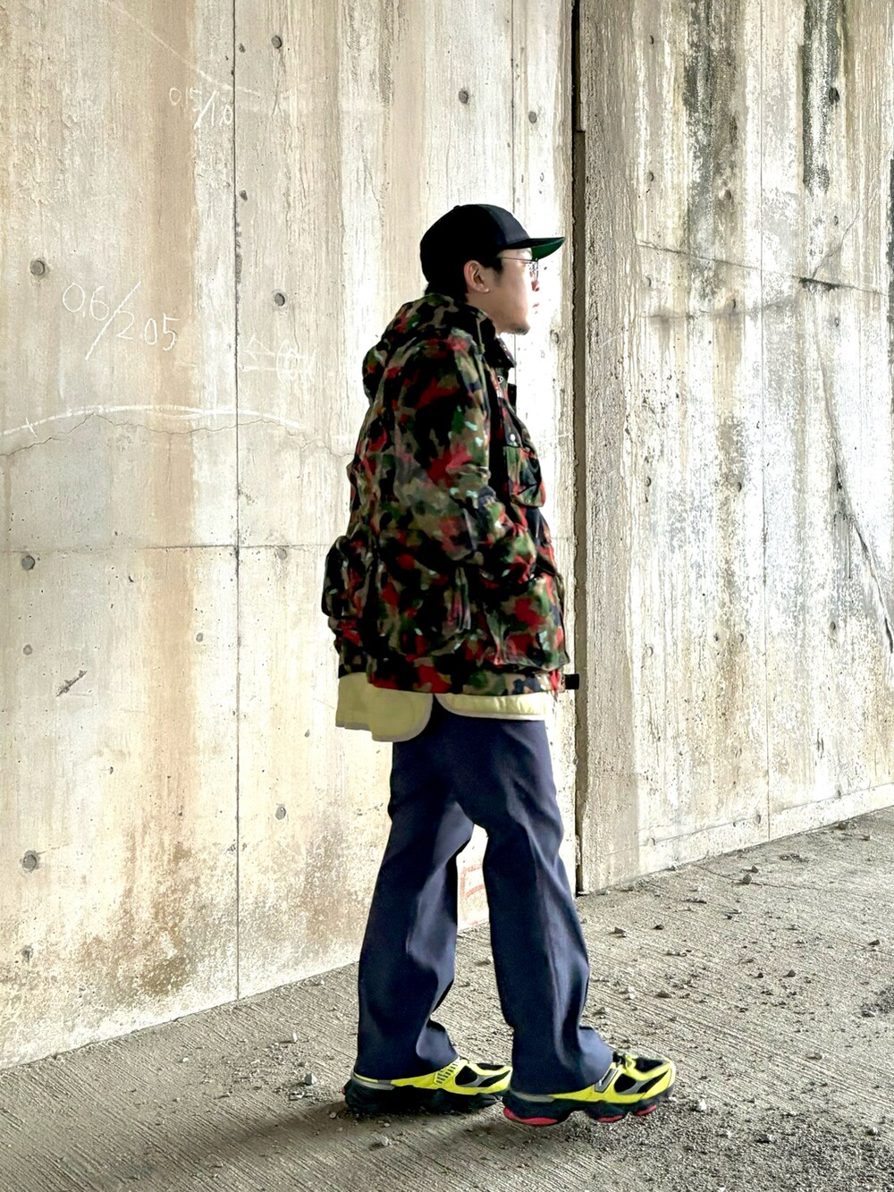 イエロー系のスニーカー、ブルー系のスラックス、その他のミリタリージャケットを着用したメンズの冬コーディネートの2枚目の写真