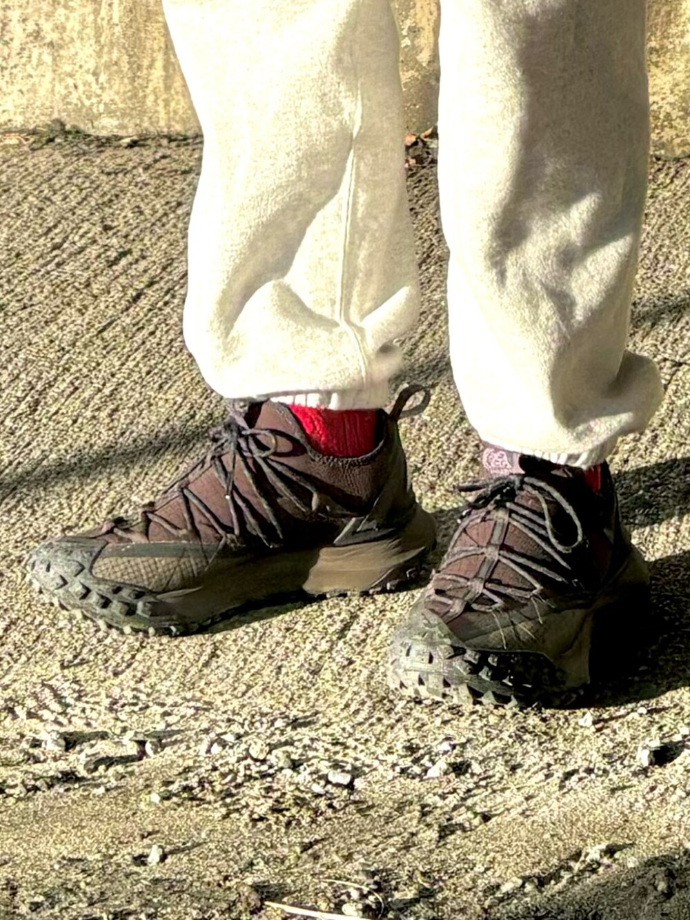 ブラック系のスニーカー、グレー系のスウェットパンツ、パープル系のベストを着用したメンズの冬コーディネートの4枚目の写真