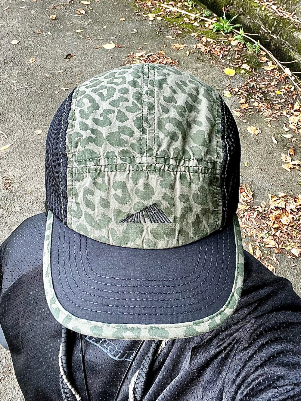 ホワイト系のスニーカー、ブラック系のカーゴパンツ、ブラック系のTシャツ/カットソーを着用したメンズの夏コーディネートの5枚目の写真